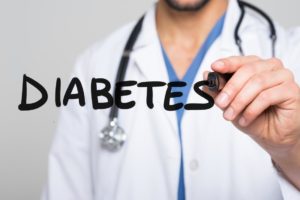 A doctor writing the word "diabetes"