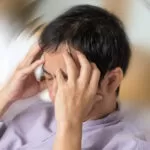 Vertigo illness concept. Man hands on his head felling headache